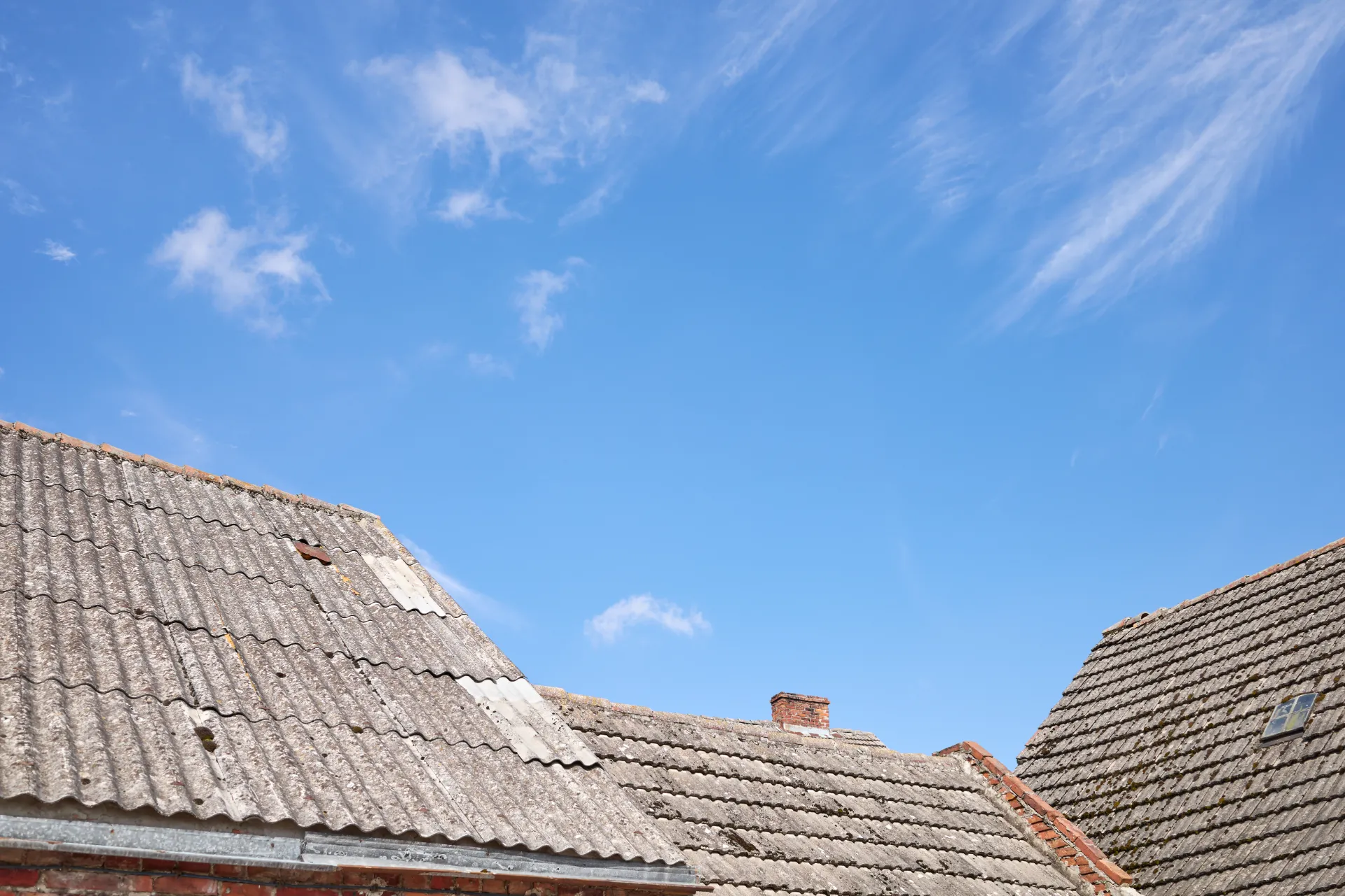 Roofer inspecting shingles for damage