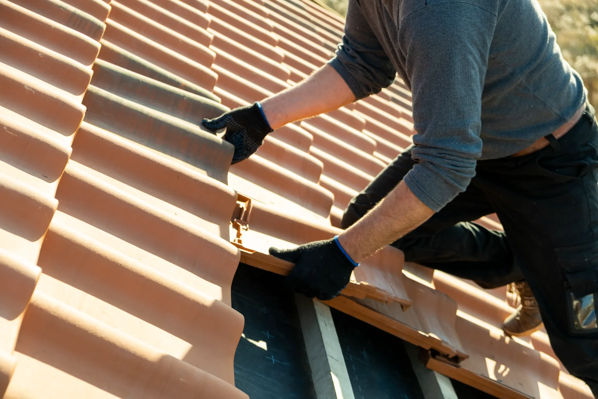 Roofer inspecting shingles for damage